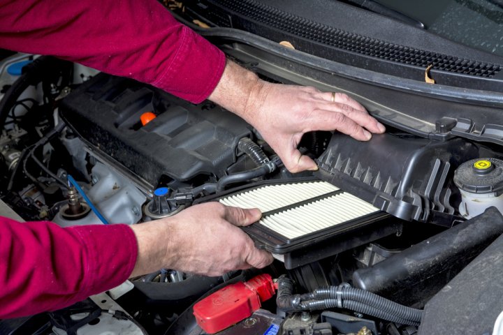 Description: man cleaning the air filter of his car